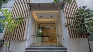 A hotel entrance with a reception desk, a staircase, and potted plants. - Treebo Regency - Bund Garden, Dhole Patil Road (Pune)