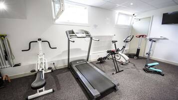 A gym with treadmills, elliptical machines, and a stationary bike.