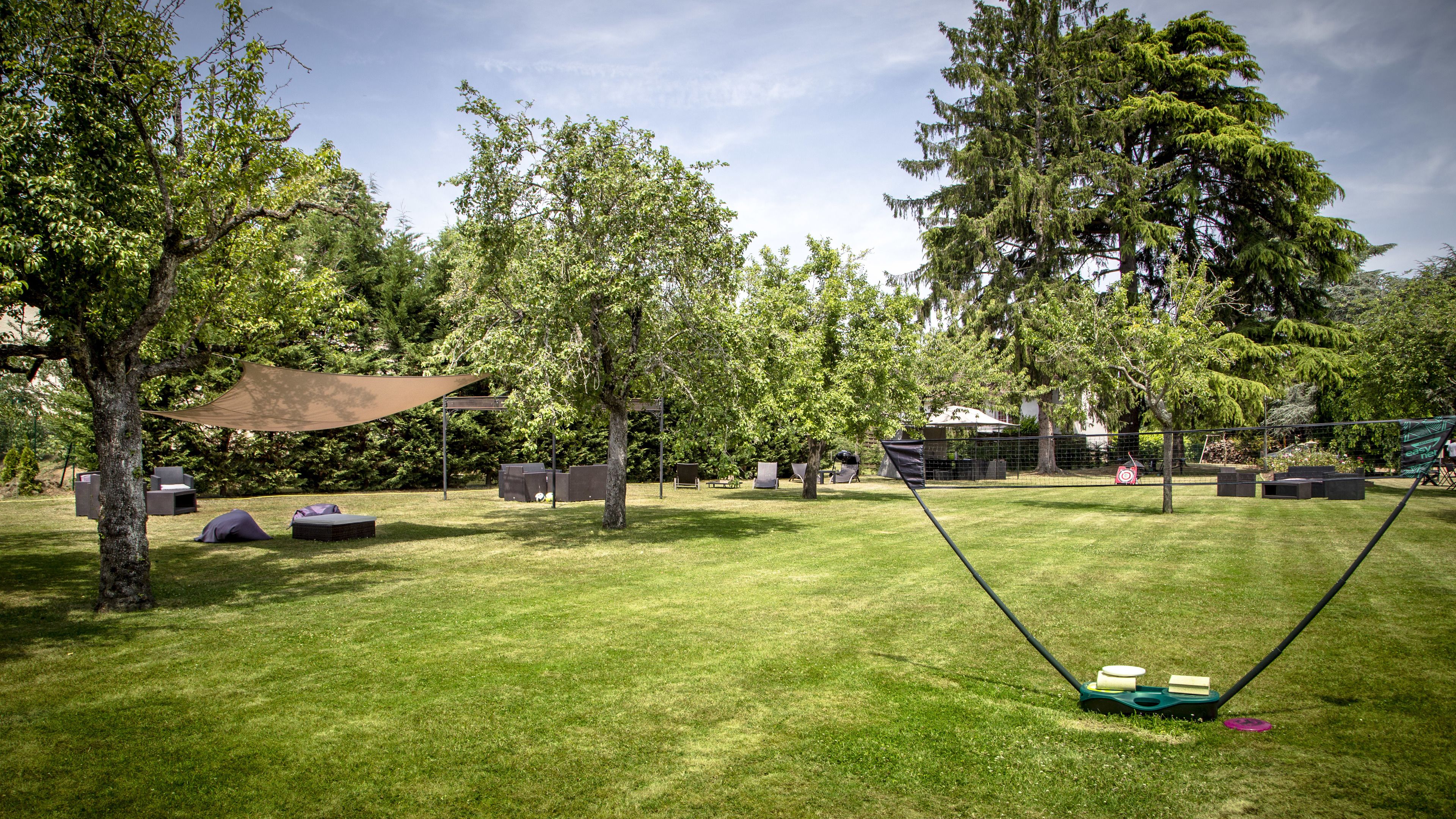 A well-maintained grassy area with picnic tables, a hammock, and a swing set.