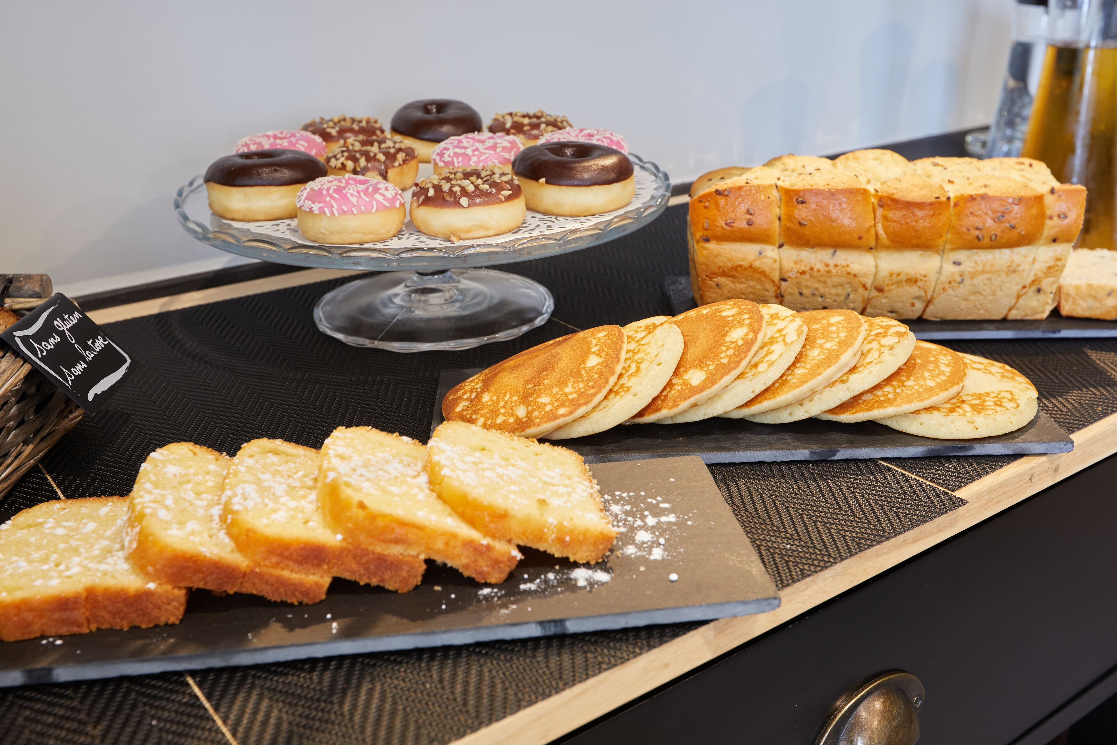 Une variété de viennoiseries et de pains présentés sur un plateau.