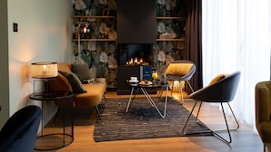 Un salon moderne avec une cheminée, un canapé, une table basse et une bibliothèque.