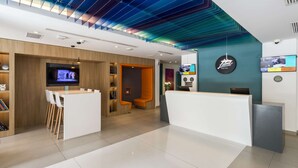 A hotel reception area with a modern design, including a reception desk, seating area, and a television screen. - Libre Hotel, BW Signature Collection (Lima)