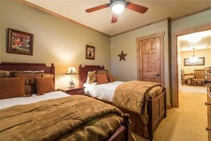 A bedroom with two beds, wooden headboards, a ceiling fan, and a star decoration on the wall. - 4110 Aspen Lodge, Trappeur's Crossing Apartment 2 (Steamboat Springs)