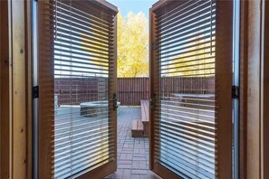 A view through open wooden blinds to a patio area with a wooden deck and a bench. - 4110 Aspen Lodge, Trappeur's Crossing Apartment 2 (Steamboat Springs)