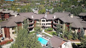 A resort with multiple buildings, a central pool, and surrounding greenery. - 4201 Aspen Lodge, Trappeur's Crossing Apartment 3 (Steamboat Springs)