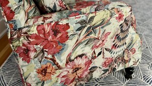 A living room with floral-patterned sofas and a geometric patterned rug. - Charred Oaks Inn (Versailles)