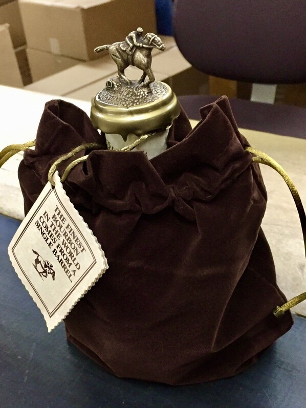A brown drawstring bag with a tag that reads "THE FINEST BOURBON IN THE WORLD COMES FROM A SINGLE BARREL."