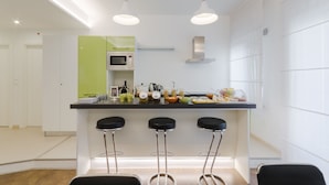 Une cuisine moderne dotée d’un îlot central, de tabourets de bar et d’un four à micro-ondes.