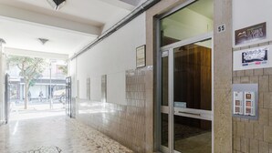 L’entrée d’un hôtel, avec un sol carrelé, une porte en verre et une enseigne indiquant le numéro de chambre : 55.