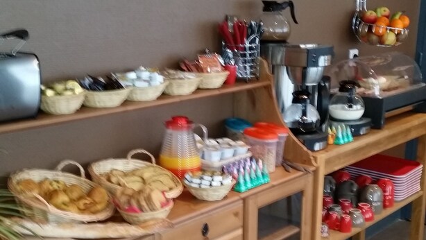 A buffet setup with various food items and utensils on a wooden table. - Hôtel La Pause (Evreux)