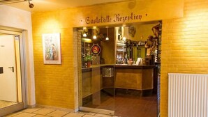 A reception area with a glass door, a sign above reading "Eastständte Rezeption," and a poster on the wall. - Erbenholz Hotel (Laatzen)