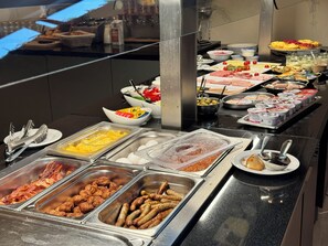 A buffet with various food options including meats, cheeses, and fruits. - Erbenholz Hotel (Laatzen)