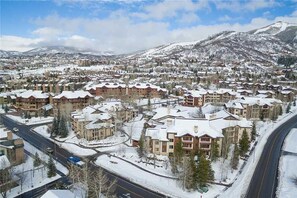 A snow-covered town with multiple buildings, roads, and a mountain in the background. - 5114 Emerald Lodge, Trappeur's Crossing Apartment 1 (Steamboat Springs)