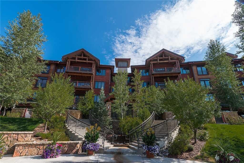 Ein mehrstöckiges Hotel mit einer zentralen Treppe, Balkonen und einem angelegten Garten.