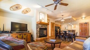 A cozy living room with a fireplace, a television, and comfortable seating. - 2106 Timberline Lodge, Trappeur's Crossing Apartment 2 (Steamboat Springs)