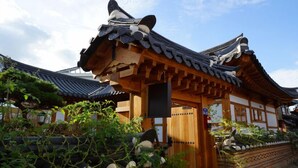 A traditional Japanese building with a wooden structure, a tiled roof, and a stone pathway leading to the entrance. - The Mumum (Jeonju)