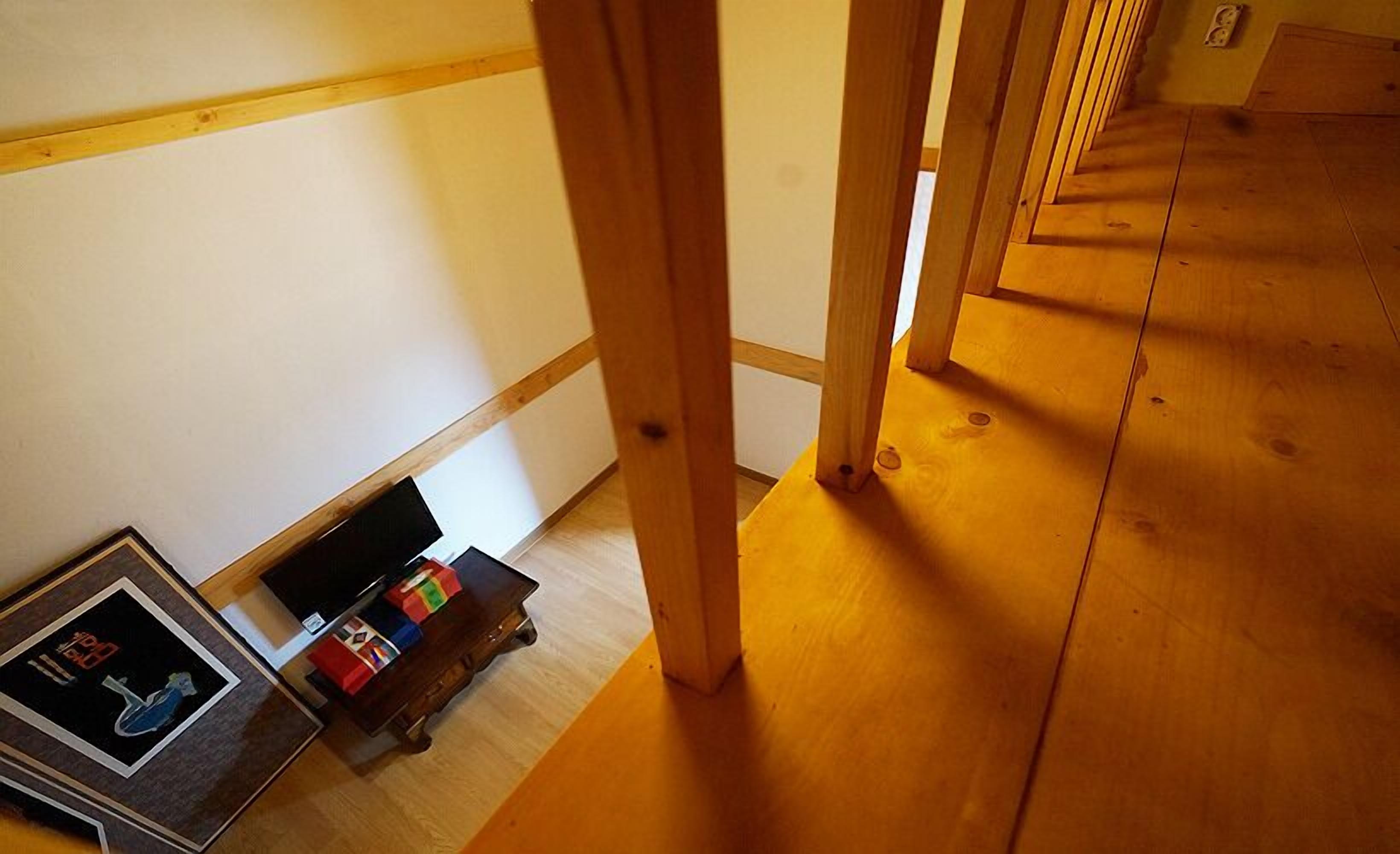 A wooden floor with a small table and a framed picture.