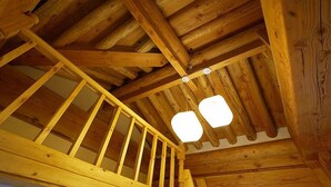 A wooden staircase with a railing, leading to a high ceiling with exposed beams. - The Mumum (Jeonju)