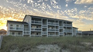 Ein mehrstöckiges Gebäude mit Balkonen in der Nähe einer Sanddüne.