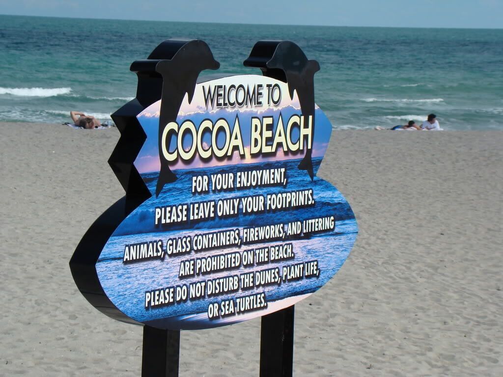 A beach sign with a message about preserving the environment.