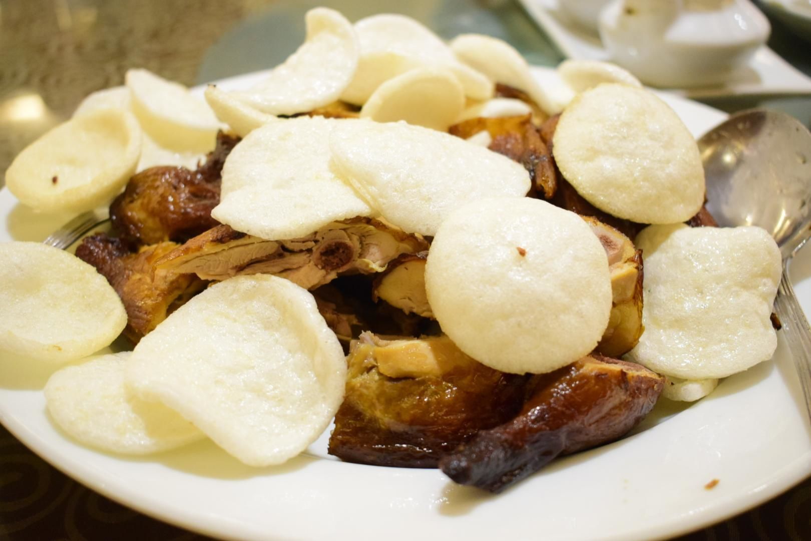 A plate of meat with round white items on top.