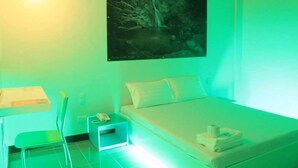 Una habitación con una cama, una mesita de noche, una silla y un cuadro de una cascada.