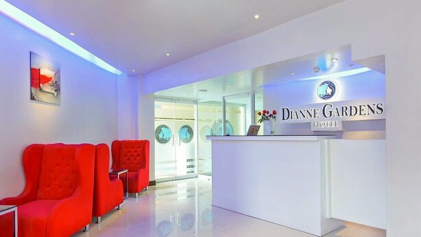 Zona de recepción con diseño moderno, que incluye un mostrador y asientos rojos.