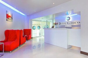 A reception area with a modern design, featuring a reception desk and red seating.