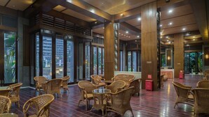 A spacious indoor area with wicker furniture and large windows. - Sanya Baohong Shang Haihuating boutique hotel (Sanya)