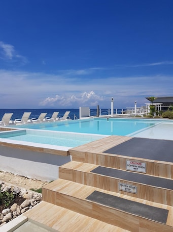 Una piscina al aire libre, sillones reclinables de piscina