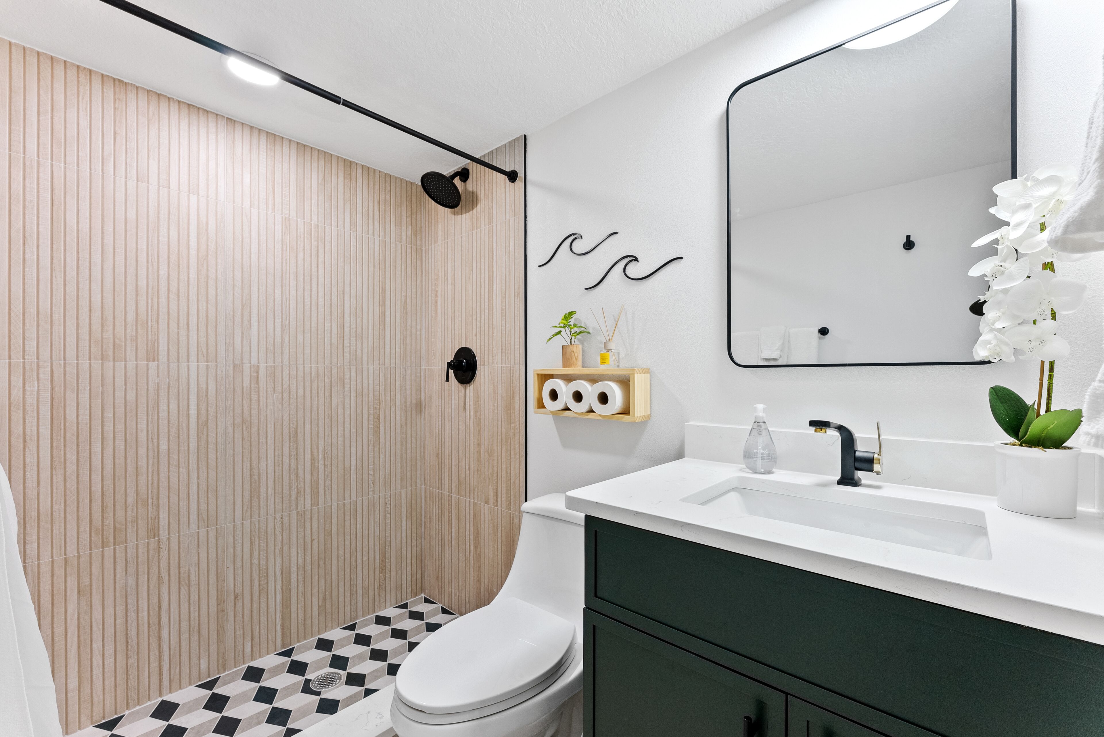 A modern bathroom with a toilet, sink, and shower.