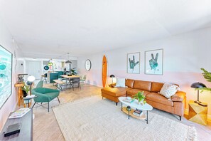 Una sala moderna con sofá, mesa de centro y una decoración con una tabla de surf.