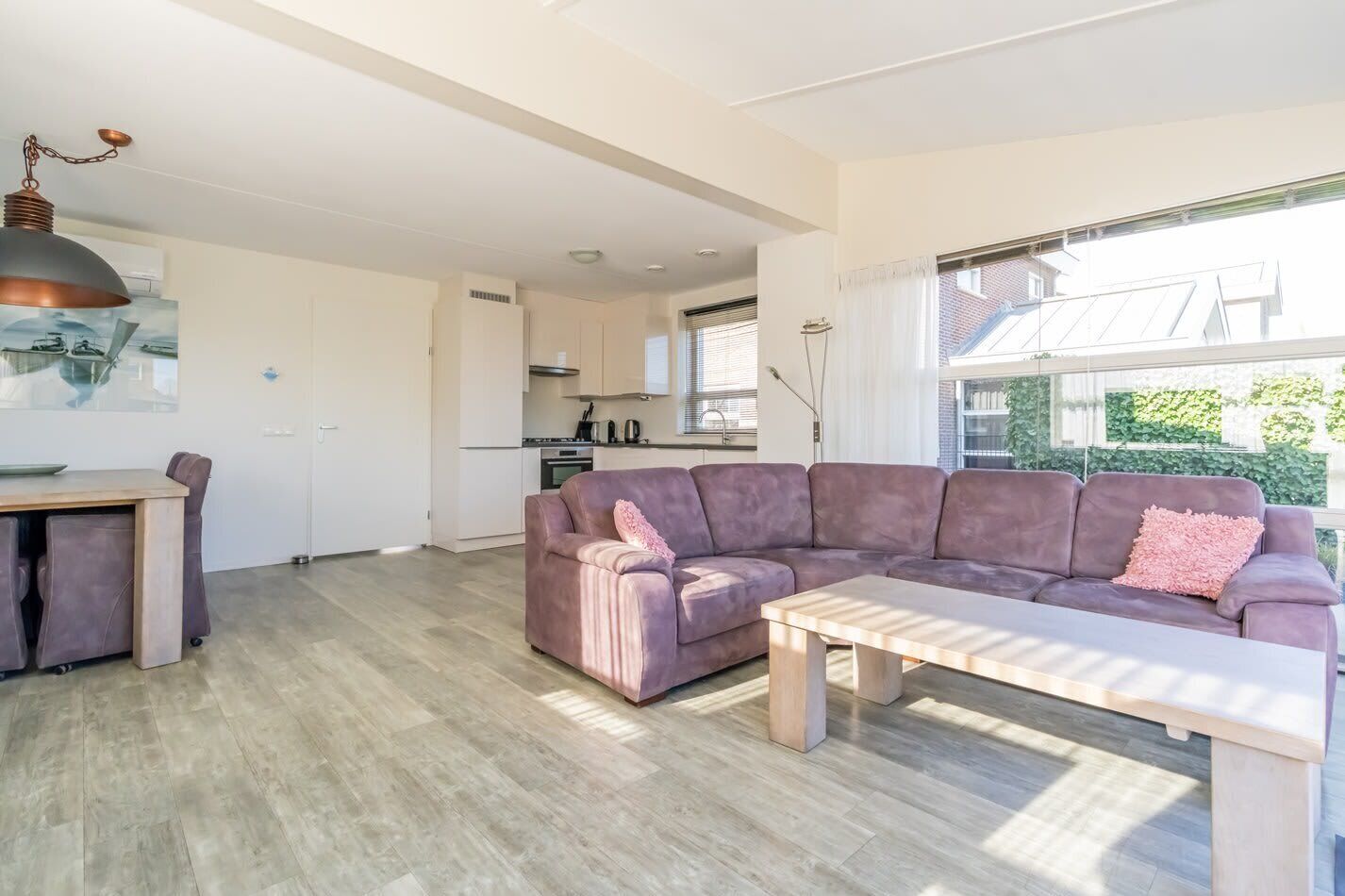 Ein modernes Wohnzimmer mit einer Couch, einem Couchtisch und einem Essbereich mit Tisch und Stühlen.
