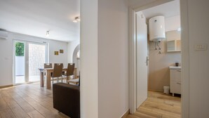 A modern interior with a dining area, a kitchen, and a bathroom.