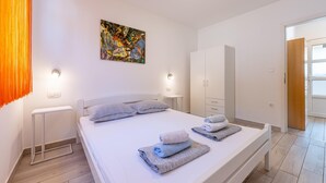 A modern bedroom with a bed, bedside tables, a wardrobe, and a painting on the wall.