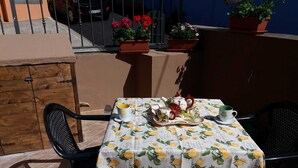 A table set outdoors with a tablecloth featuring lemon prints, a teapot, cups, and a tray with food. - Sole&Cuore is an elegant apartment accessorized and close to the beautiful CHIA   (Domus De Maria)