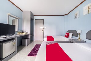 A hotel room with two beds, a TV, a desk, and a mirror.