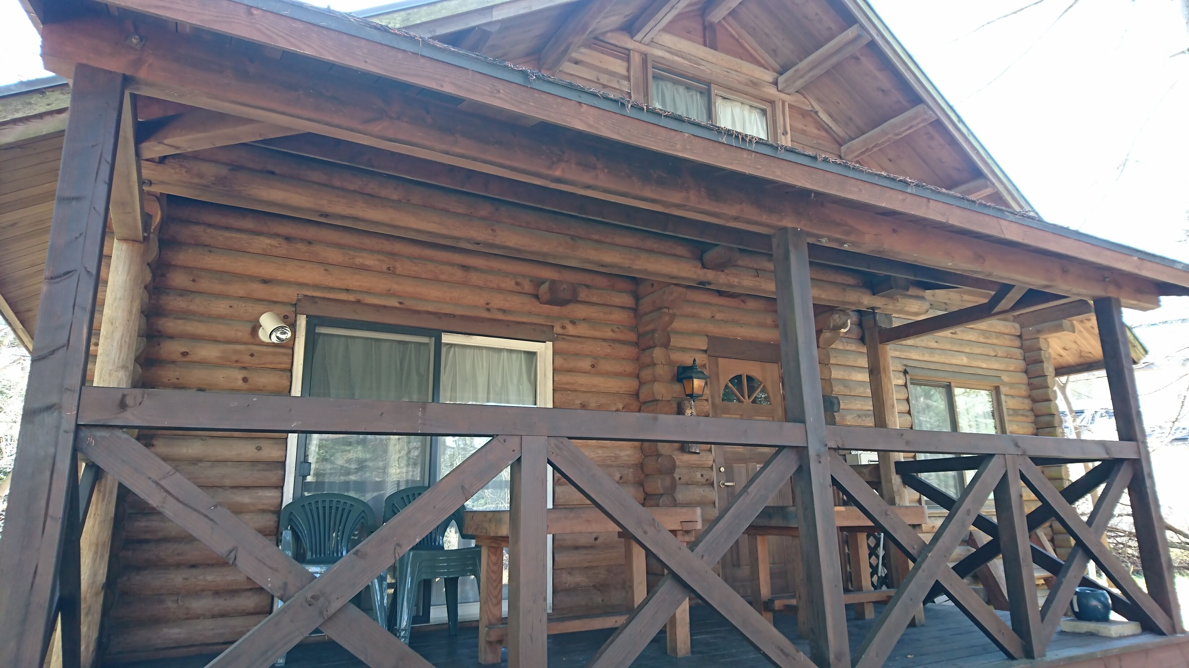 Eine Holzhütte mit Veranda, Fenster und Tür.