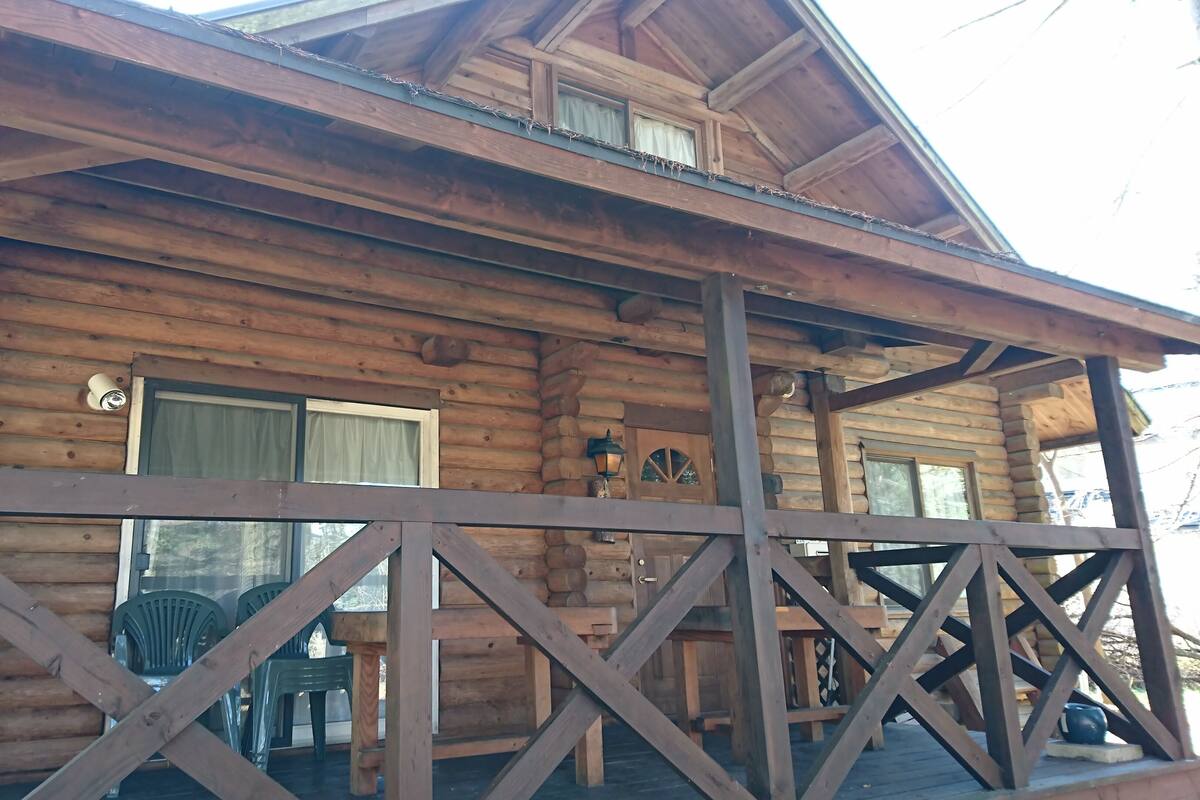 Eine Holzhütte mit Veranda, Fenster und Tür.
