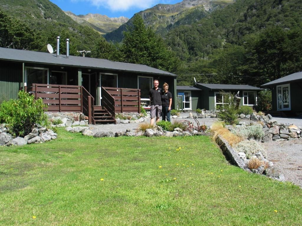 A cabin with a wooden deck and a stone pathway leading to the entrance.