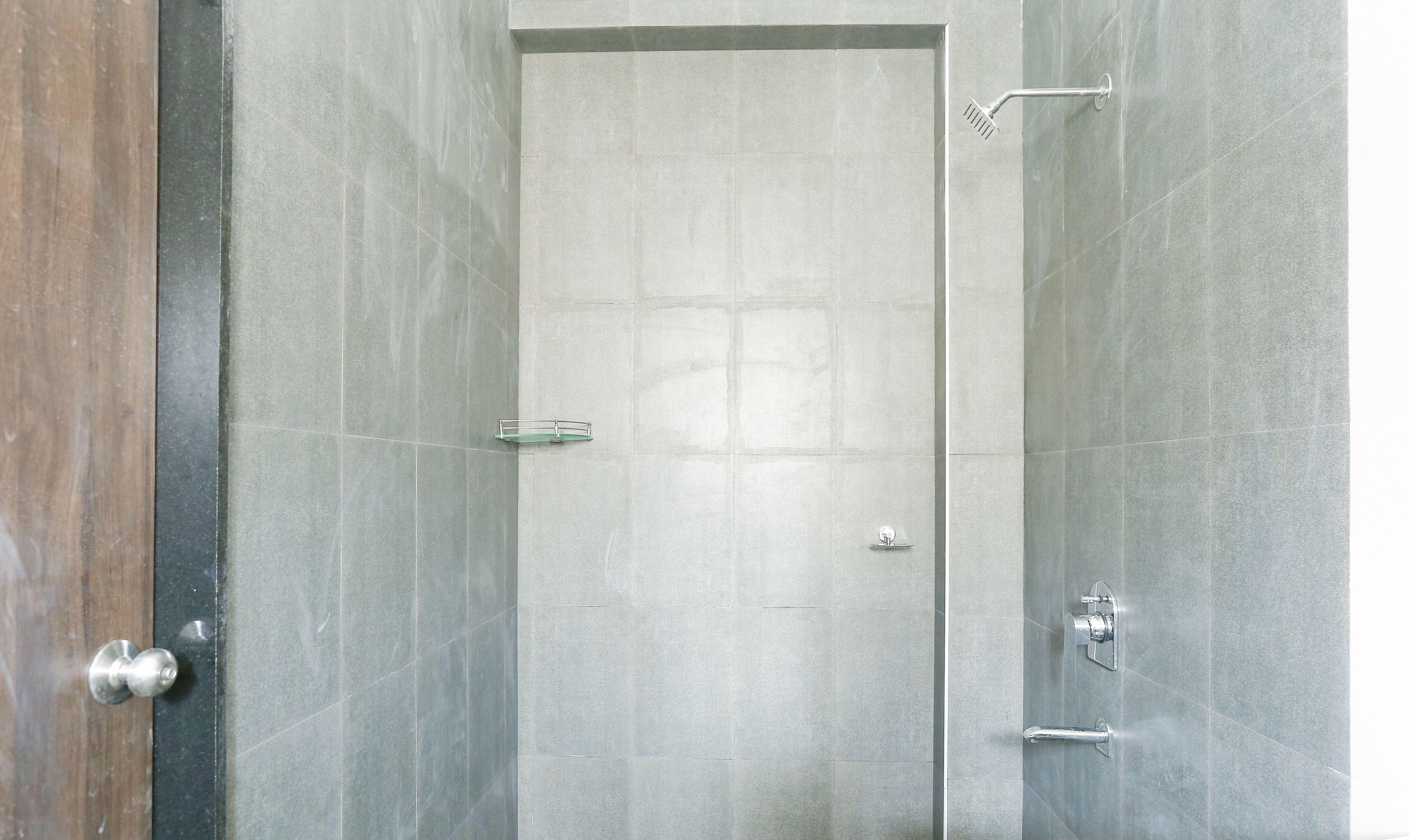 A bathroom with a shower, a glass door, and a towel rack.