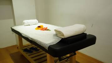 Cozy retreat with a single bed, white sheet, and a bouquet of flowers.