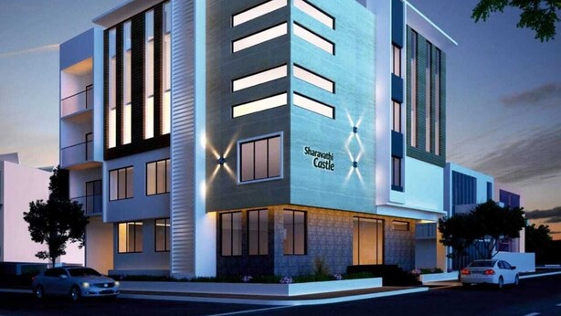 A modern hotel with a flat facade, large windows, and a sign reading "Sharavathi Castle". - Silicon Inn (Bengaluru)