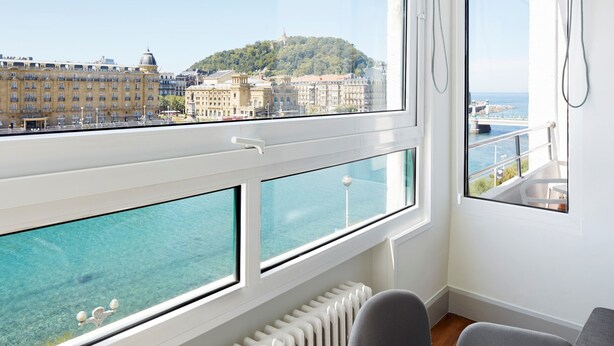 A room with a view of a coastal city, a window with a view of the sea, and a radiator. - Okendo by FeelFree Rentals (San Sebastián)