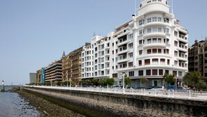 A multi-story hotel with balconies, located near a waterfront. - Okendo by FeelFree Rentals (San Sebastián)