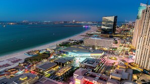 Un paisaje urbano costero con un hotel destacado, frente a la playa y edificios modernos.