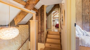 A wooden staircase with a white wall and a hanging light fixture. - The Manger, Perched in an elevated position within the Blackdown Hills National Landscape. (Axminster)