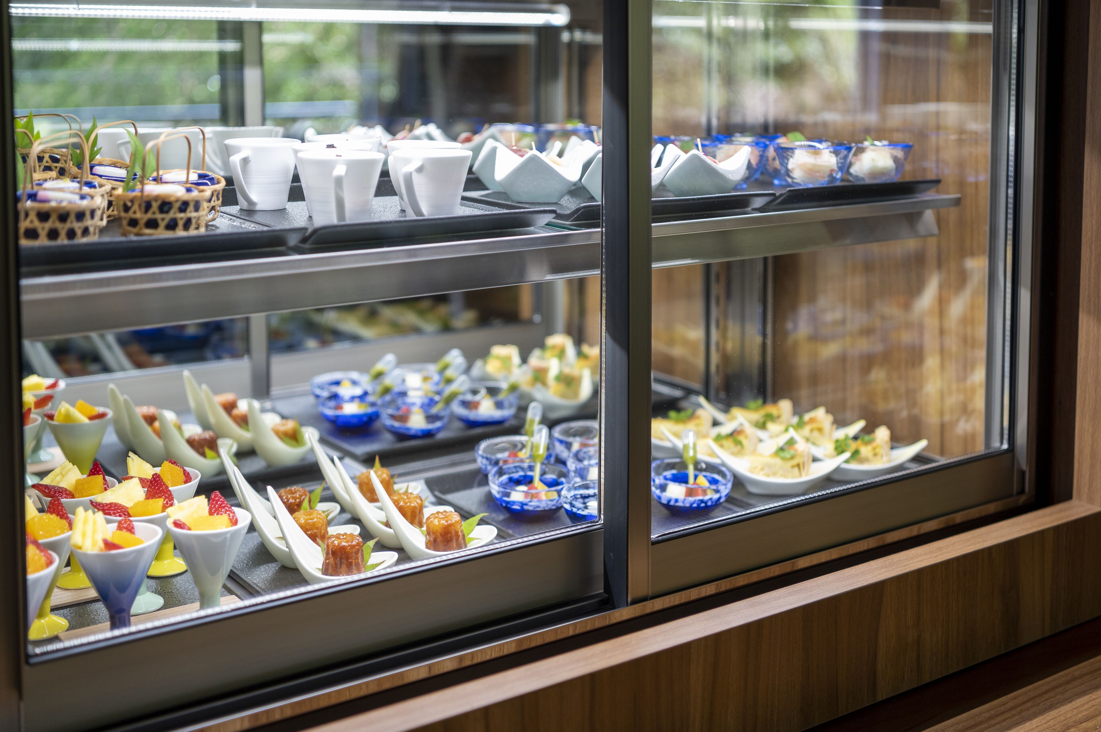 A buffet with various food items displayed in glass containers.