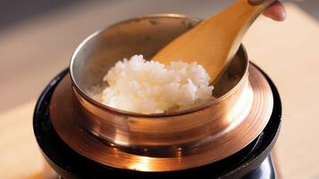 A bowl of white rice on a black and copper base.