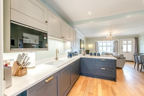 A modern kitchen with a Bosch microwave, a sink, and a coffee machine.